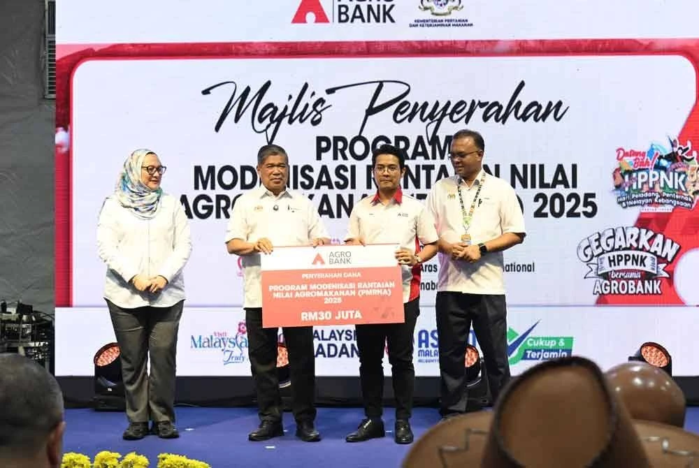Menteri Pertanian dan Keterjaminan Makanan, Datuk Seri Mohamad Sabu (dua dari kiri) menyempurnakan simbolik penyerahan dana PMRNA 2025 kepada Ketua Pegawai Pembangunan Agrobank, Ahmad Ariff Abu Bakar (dua dari kanan) disaksikan oleh Ketua Setiausaha KPKM, Datuk Seri Isham Ishak (kanan) dan Setiausaha Bahagian Pemodenan Pertanian Kementerian Pertanian, Aina Azza Zaid (kiri).