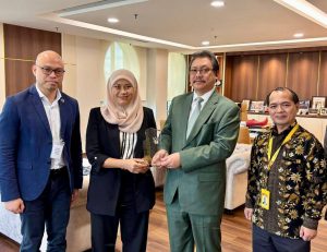 Elina (second left) hands over Dr Hazland (second right) a momento after the meeting, witnessed by Azimeer (left) and Joseph.